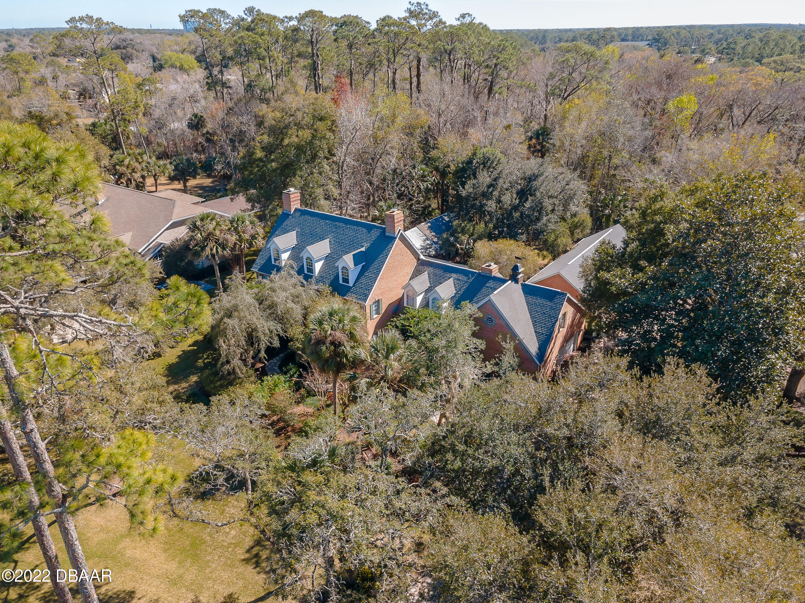 an aerial view of a house with a yard and mountain view in back