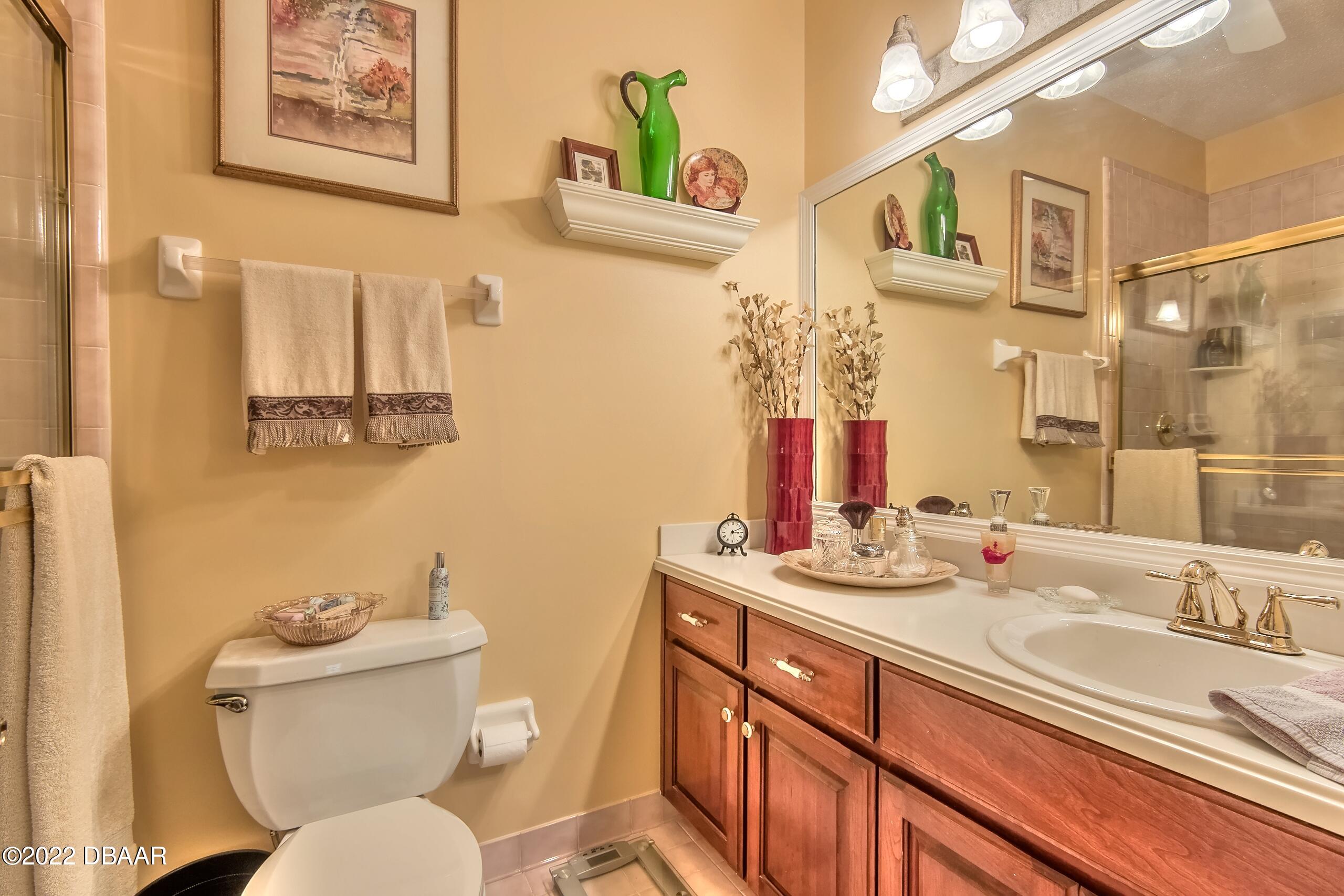 8 Moss Point Drive Ormond Beach, FL 32174 - Photo 33 of 63 a bathroom with a granite countertop toilet sink and a mirror