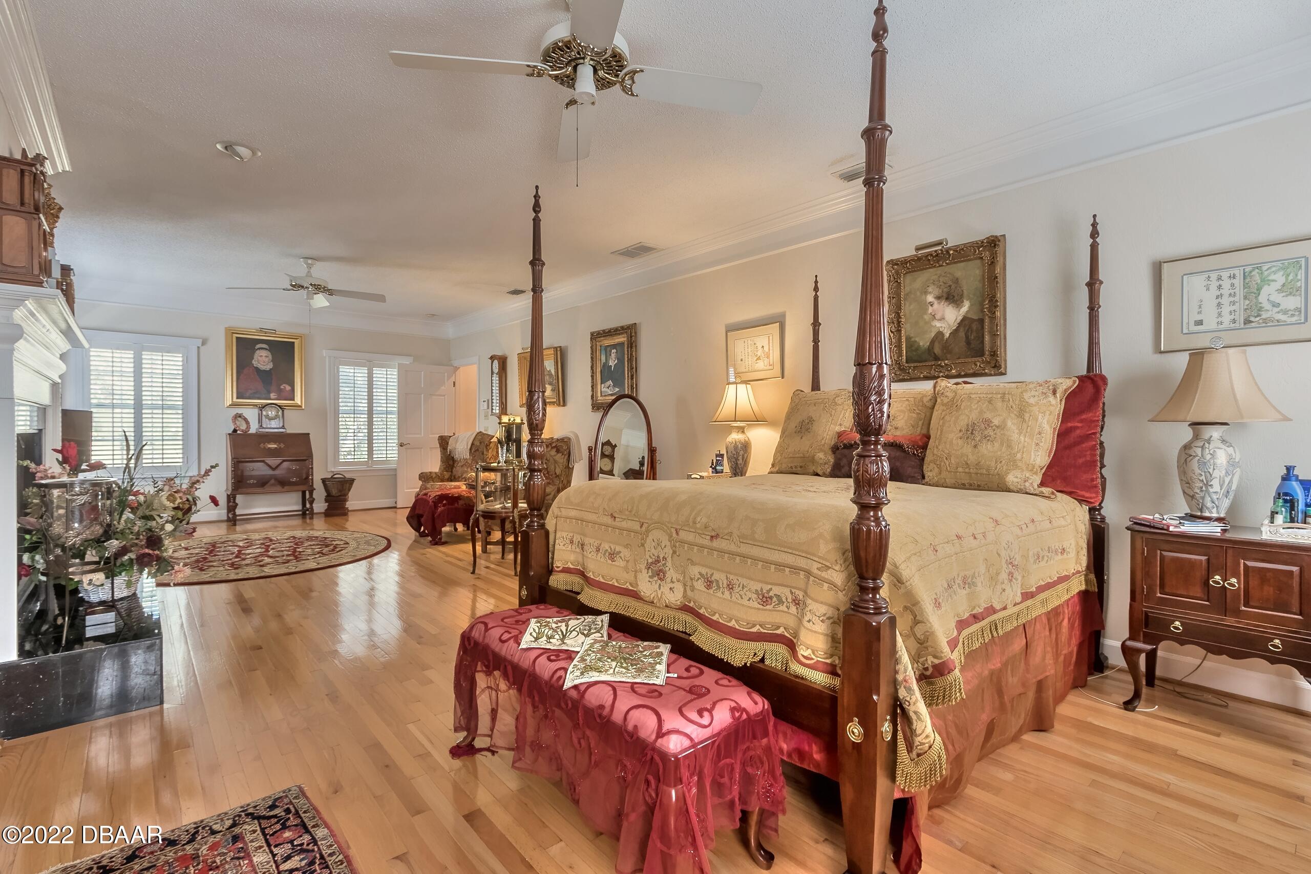 8 Moss Point Drive Ormond Beach, FL 32174 - Photo 43 of 63 a spacious bedroom with a balcony a bed and a chandelier