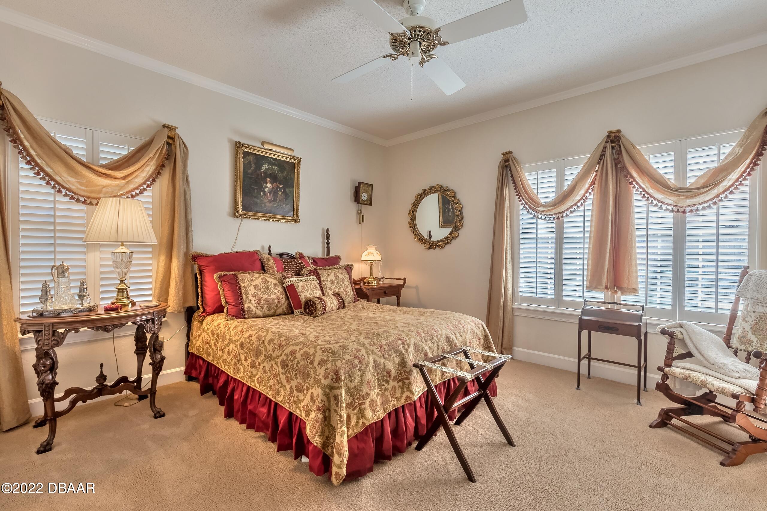 8 Moss Point Drive Ormond Beach, FL 32174 - Photo 47 of 63 a bedroom with a bed a chair and a chandelier