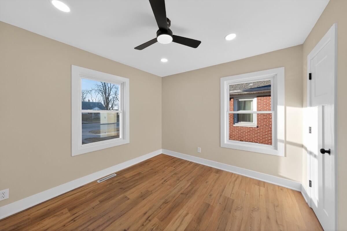 423 Cline Avenue Griffith, IN 46319 - Photo 12 of 33 a view of an empty room with a window and wooden floor