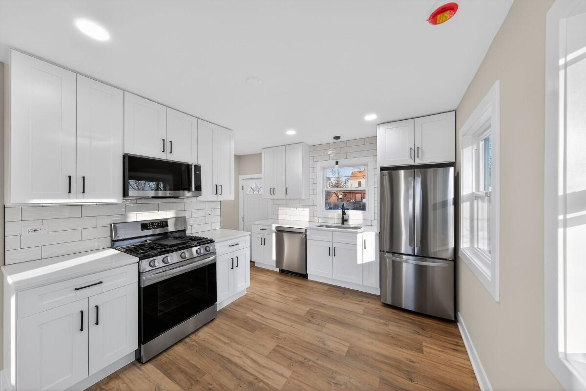 423 Cline Avenue Griffith, IN 46319 - Photo 3 of 33 a kitchen with white cabinets and stainless steel appliances