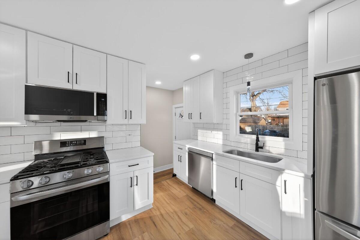 423 Cline Avenue Griffith, IN 46319 - Photo 6 of 33 a kitchen with stainless steel appliances a stove microwave and sink