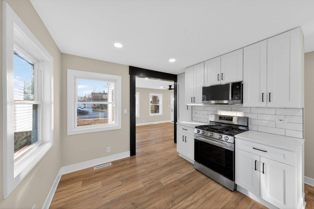 423 Cline Avenue Griffith, IN 46319 - Photo 7 of 33 a kitchen with stainless steel appliances a stove sink microwave and cabinets