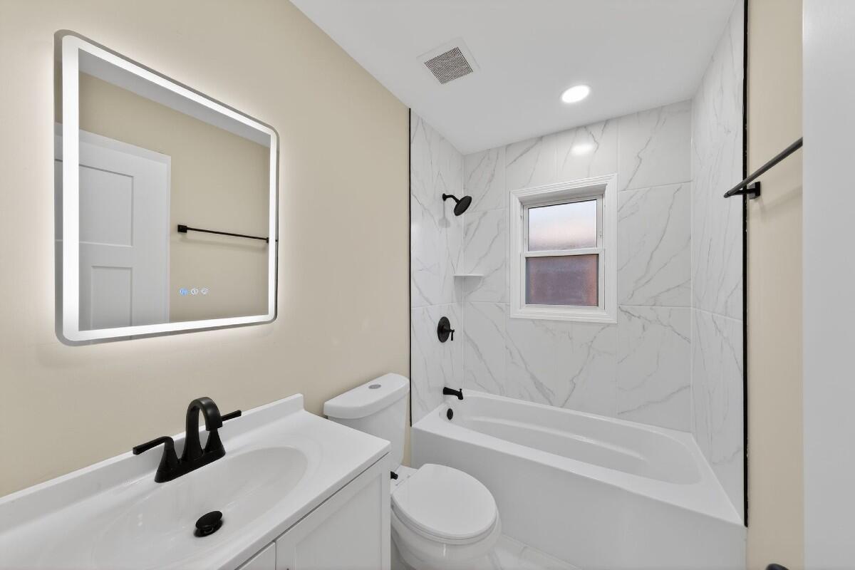 423 Cline Avenue Griffith, IN 46319 - Photo 9 of 33 a bathroom with a bathtub shower sink vanity and toilet