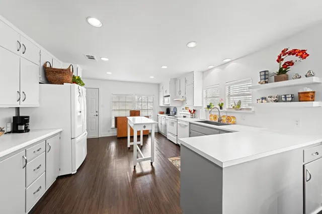 a kitchen with white cabinets and window