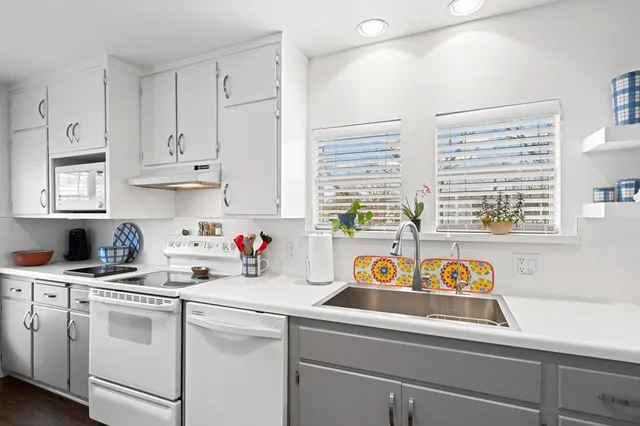 a kitchen with a sink chairs and wooden floor