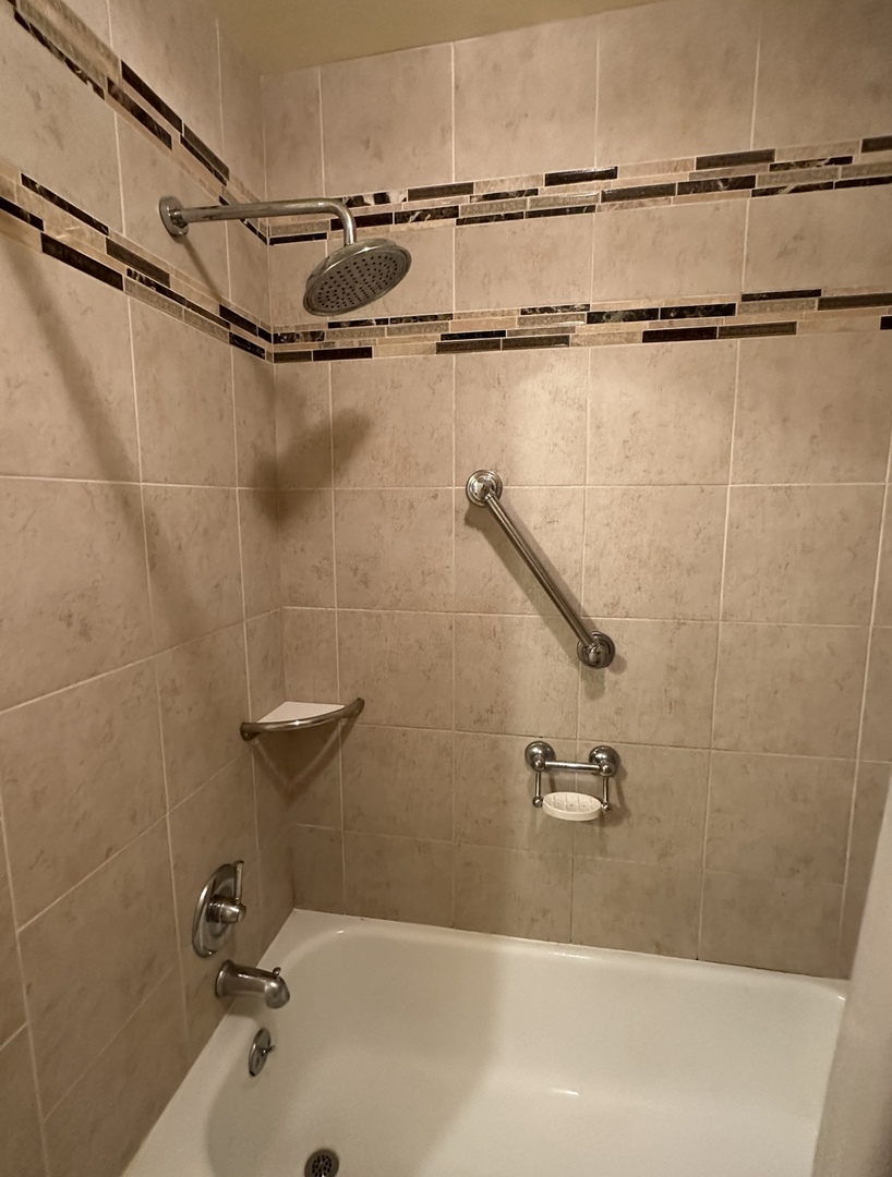 9s070 South Frontage Road, Unit 204 Willowbrook, IL 60527 - Photo 4 of 18 a bath tub sitting next to a white sink and a shower