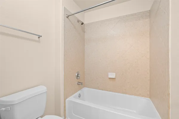 a white bath tub sitting next to a white toilet