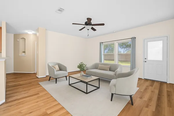 a living room with furniture and wooden floor