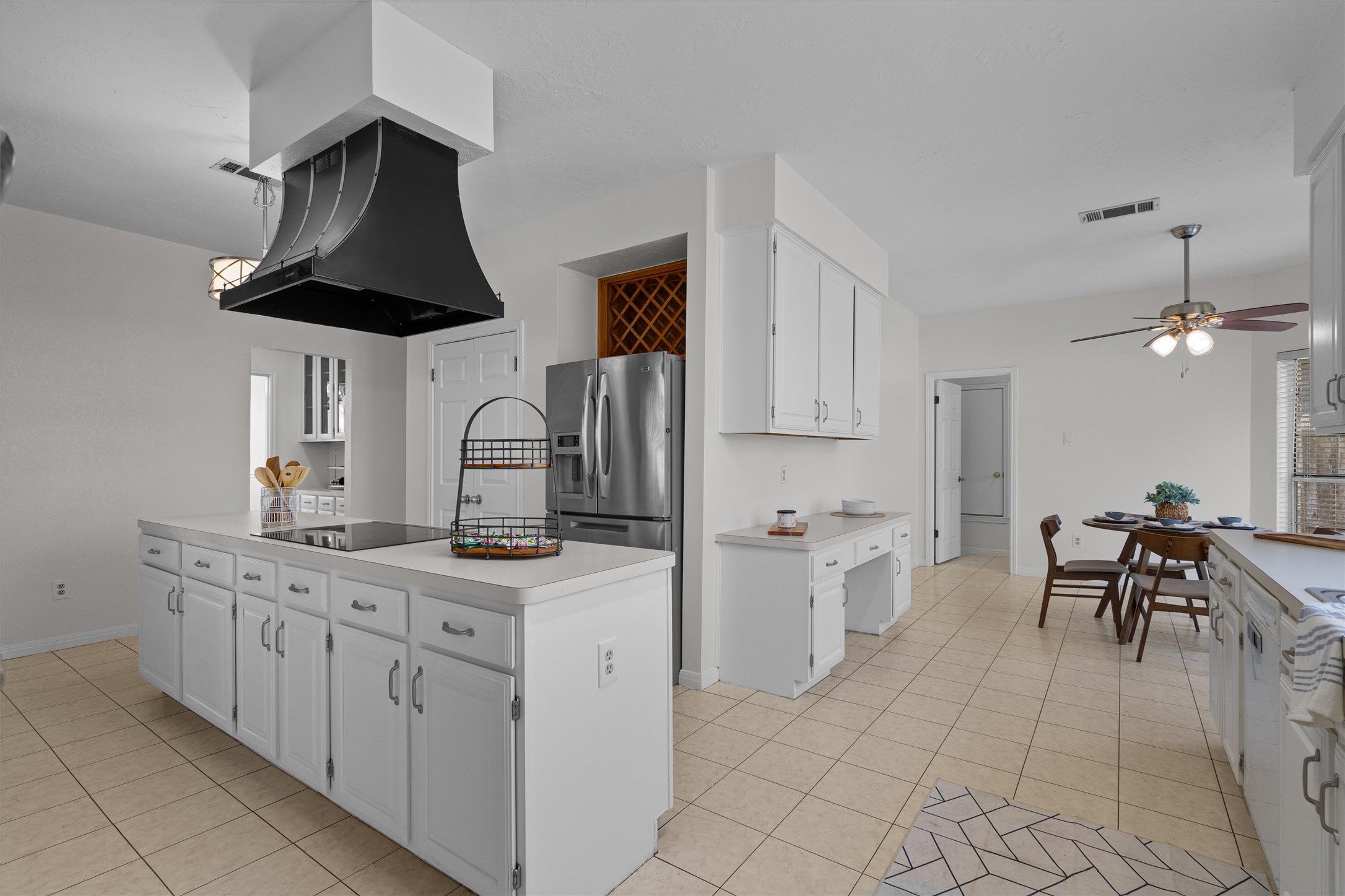 10506 Walpole Lane Austin, TX 78739 - Photo 13 of 40 Kitchen featuring white cabinets, light countertops, light tile patterned floors, and a kitchen island