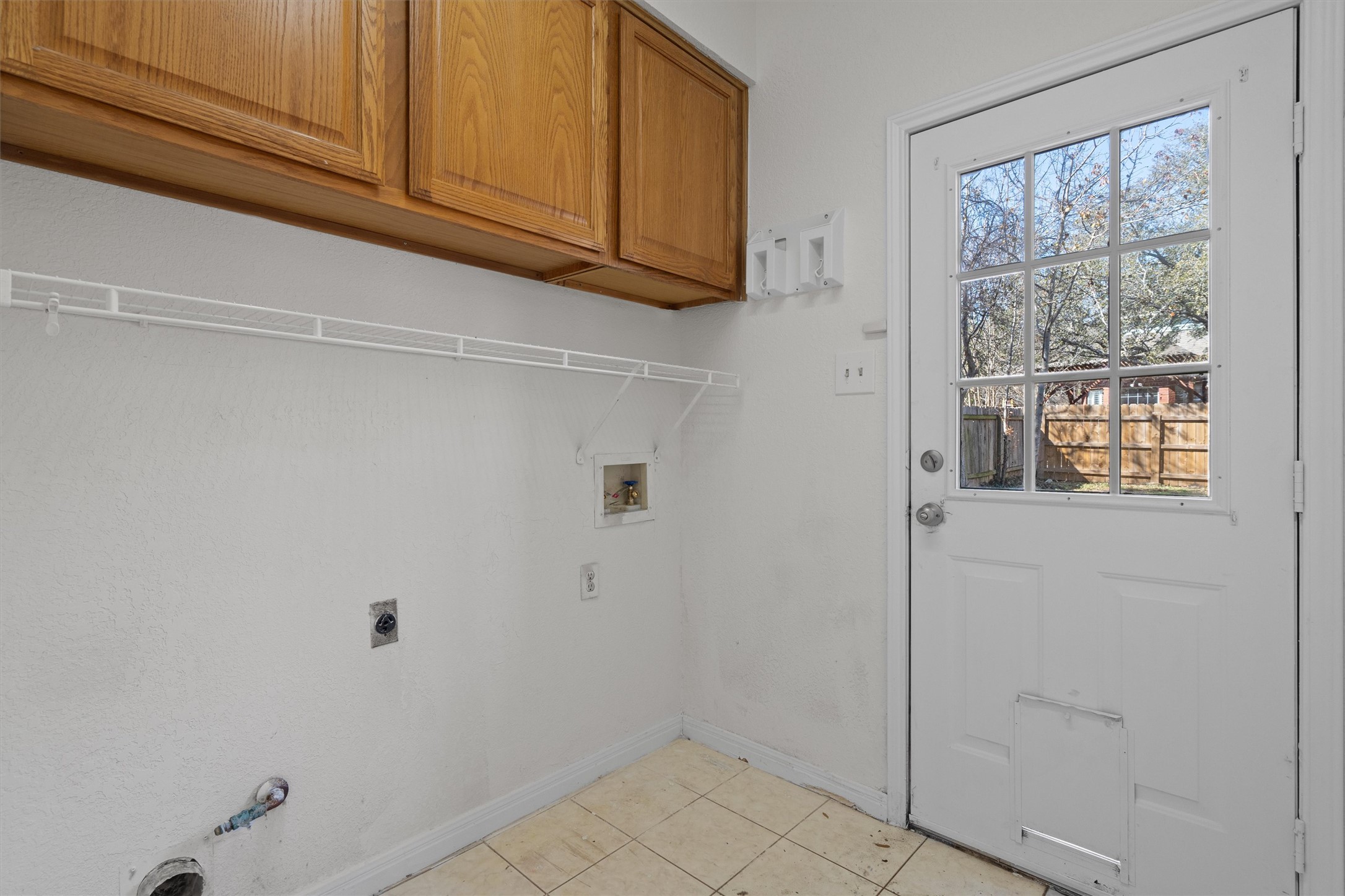 10506 Walpole Lane Austin, TX 78739 - Photo 20 of 40 Laundry area featuring washer hookup, light tile patterned flooring, cabinet space, hookup for a gas dryer, and hookup for an electric dryer