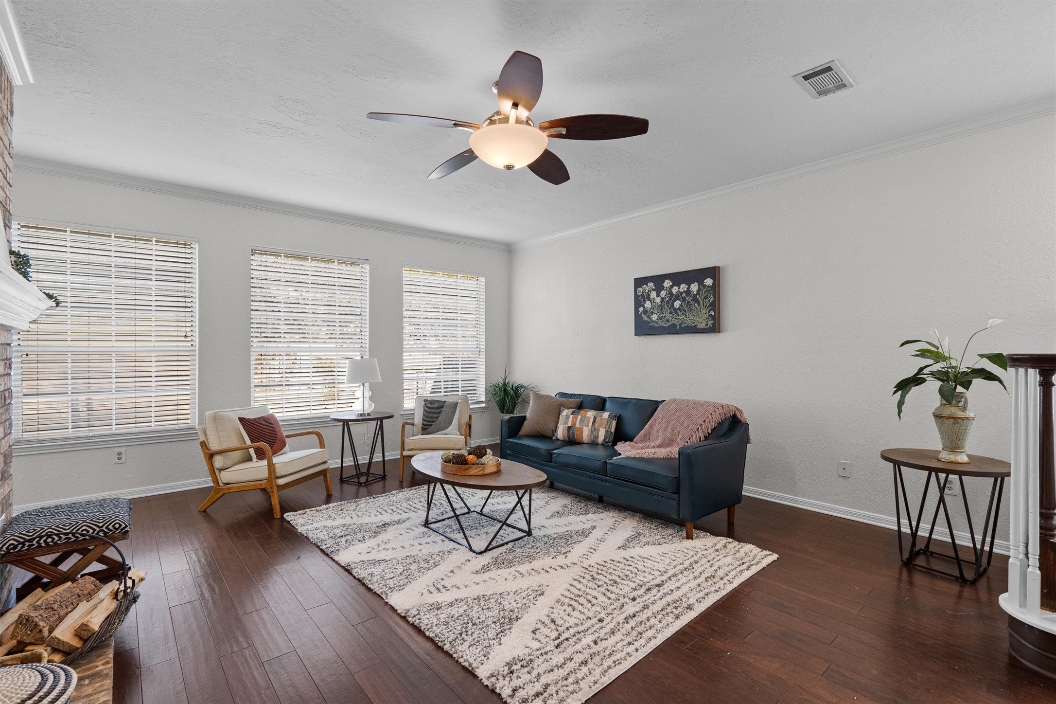 10506 Walpole Lane Austin, TX 78739 - Photo 9 of 40 Living room featuring a fireplace, a ceiling fan, dark wood-style flooring, and ornamental molding