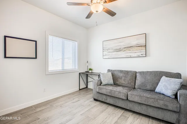 a view of a hallway with wooden floor and a bathroom