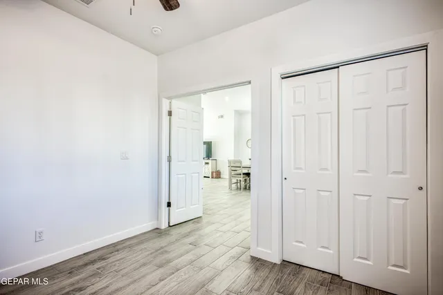 a bedroom with a large bed and a chandelier fan