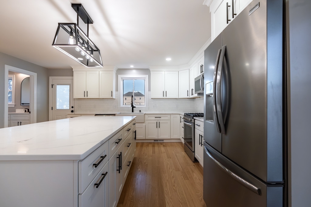 214 Horton Street Fall River, MA 02723 - Photo 16 of 40 a kitchen with a refrigerator a sink and cabinets
