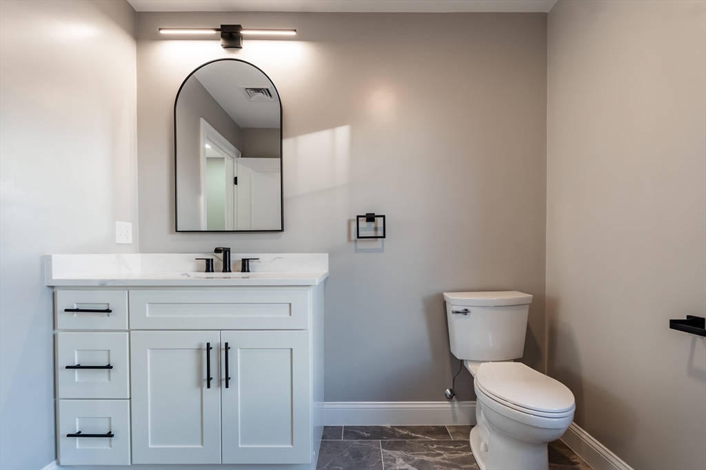 214 Horton Street Fall River, MA 02723 - Photo 20 of 40 a bathroom with a toilet sink and mirror