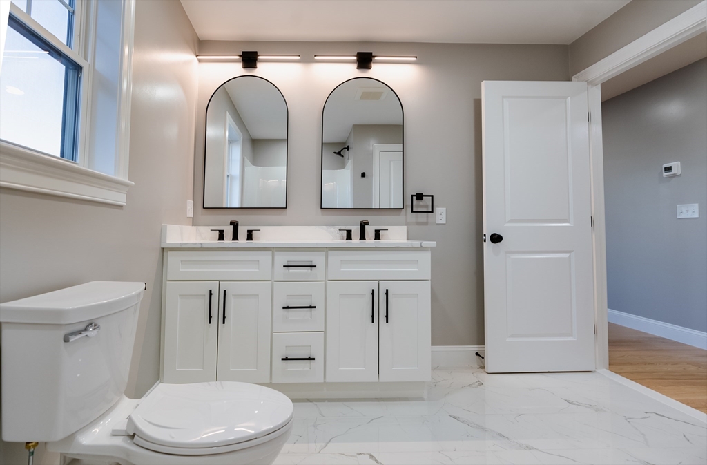 214 Horton Street Fall River, MA 02723 - Photo 29 of 40 a bathroom with a granite countertop toilet sink and mirror