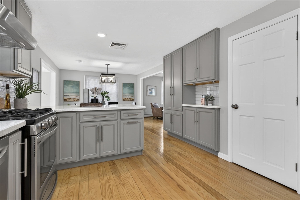 111 Goss Lane Lancaster, MA 01523 - Photo 5 of 39 a kitchen with stainless steel appliances granite countertop a stove top oven a sink dishwasher and a refrigerator with wooden floor