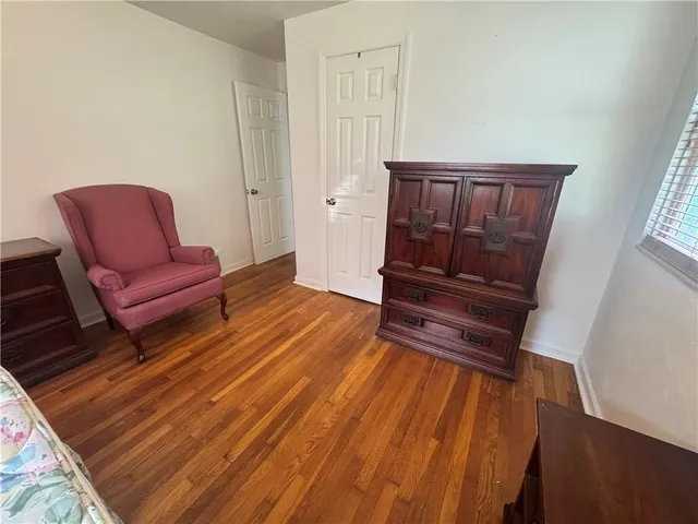 a hallway with a couch and a dresser with wooden floor