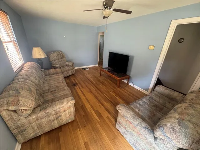 a bed sitting in a bedroom and chair next to a window