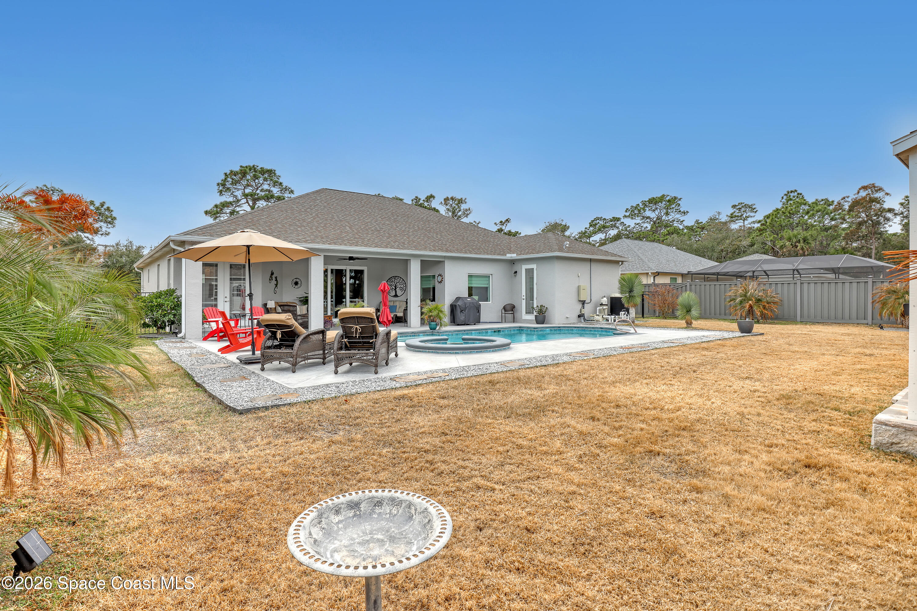 1837 Market Circle Northeast Palm Bay, FL 32905 - Photo 50 of 57 a view of a white house with a swimming pool and a yard