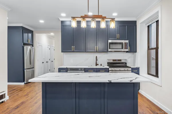 a kitchen with kitchen island granite countertop a stove cabinets and refrigerator