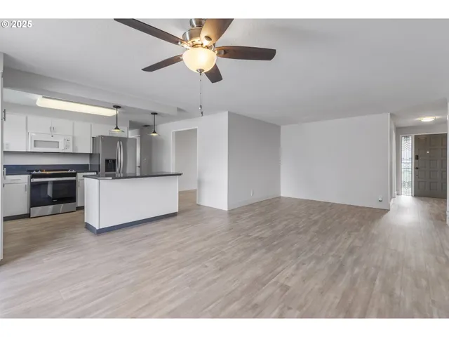 a view of kitchen with stainless steel appliances refrigerator stove microwave and cabinets