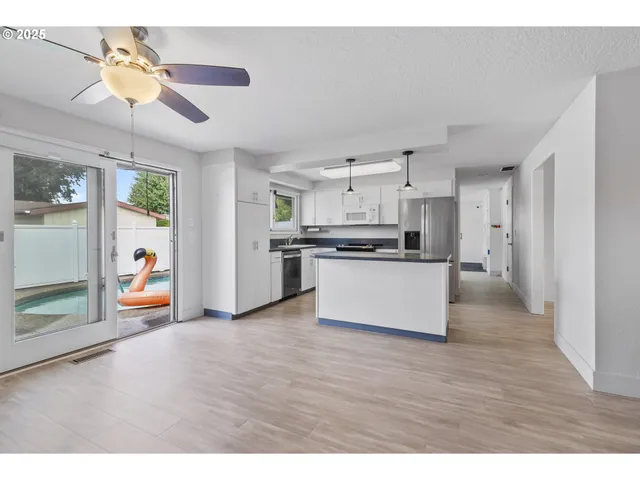 a view of kitchen with stainless steel appliances granite countertop a refrigerator and a stove