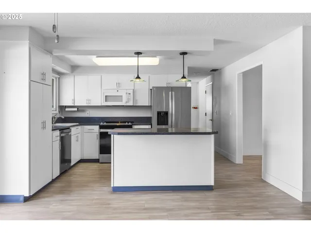 a large white kitchen with stainless steel appliances