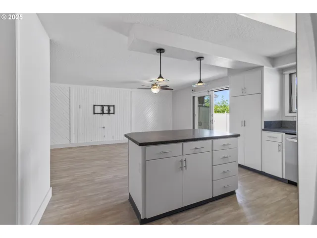 a kitchen with granite countertop a sink cabinets and wooden floor