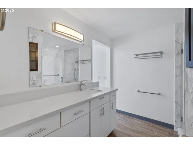 a bathroom with a shower sink and mirror