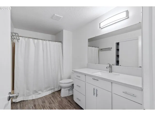 a view of a room with wooden floor and bathroom view