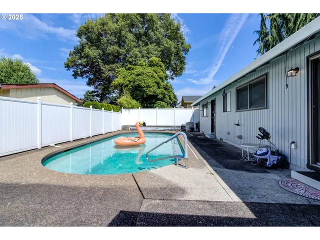 a view of a house with backyard swimming pool and sitting area