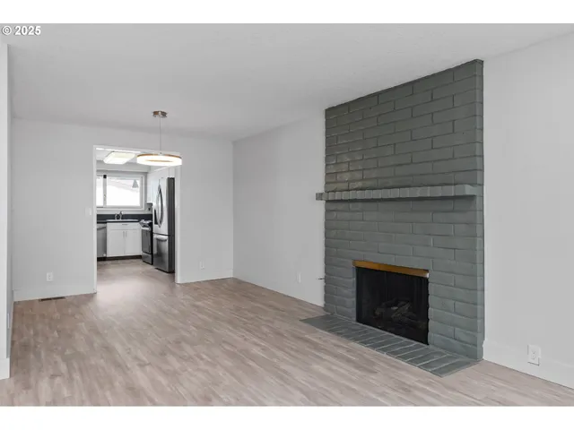 a view of an empty room with a fireplace