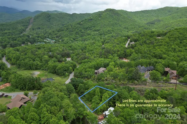 an aerial view of a house with a lush green hillside