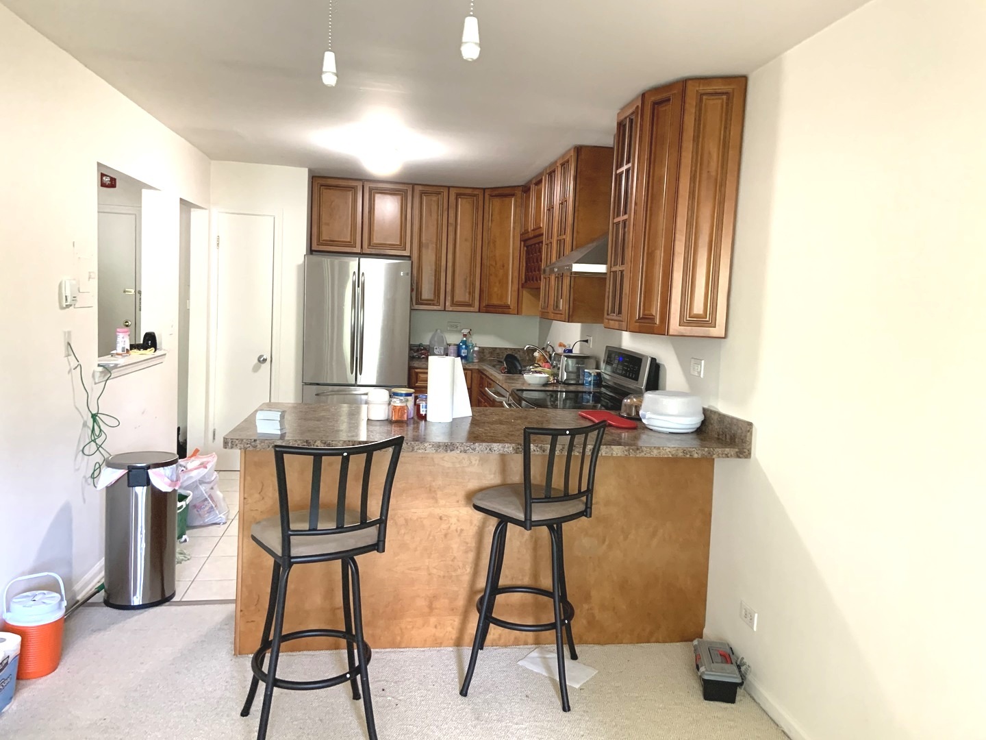 2403 South Goebbert Road, Unit 205 Arlington Heights, IL 60005 - Photo 5 of 13 a kitchen with stainless steel appliances kitchen island granite countertop a refrigerator and a stove top oven with wooden floor