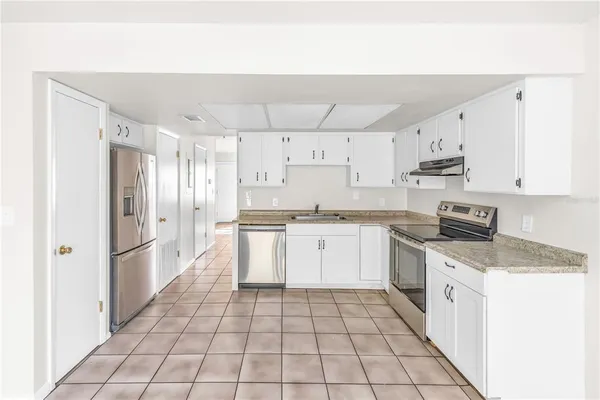 a kitchen with stainless steel appliances a refrigerator sink and cabinets