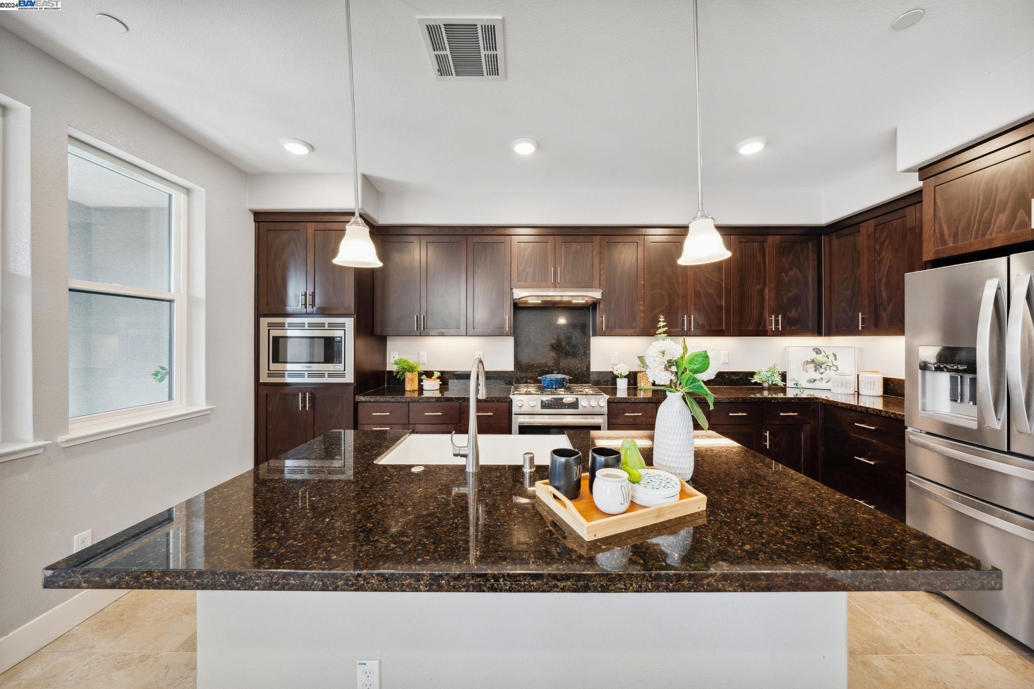 a large kitchen with lots of counter space cabinets and stainless steel appliances
