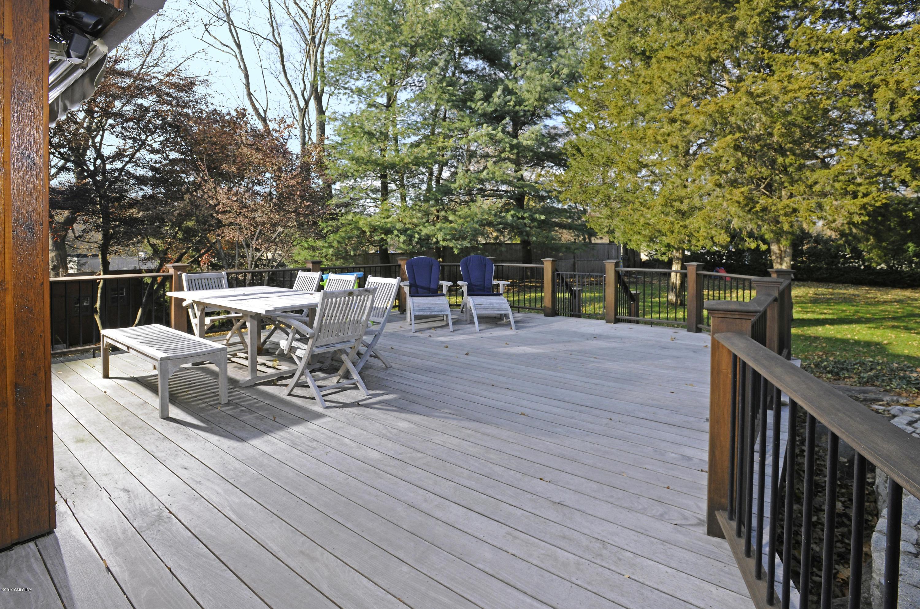 249 Shore Road Greenwich, CT 06830 - Photo 3 of 24 a view of a patio with dining table and chairs with wooden floor and fence