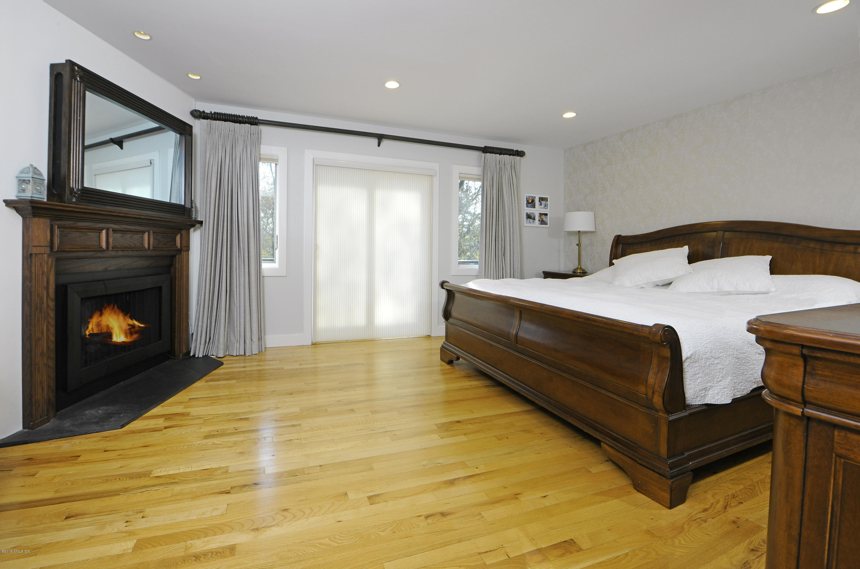249 Shore Road Greenwich, CT 06830 - Photo 9 of 24 a spacious bedroom with a bed and a fireplace