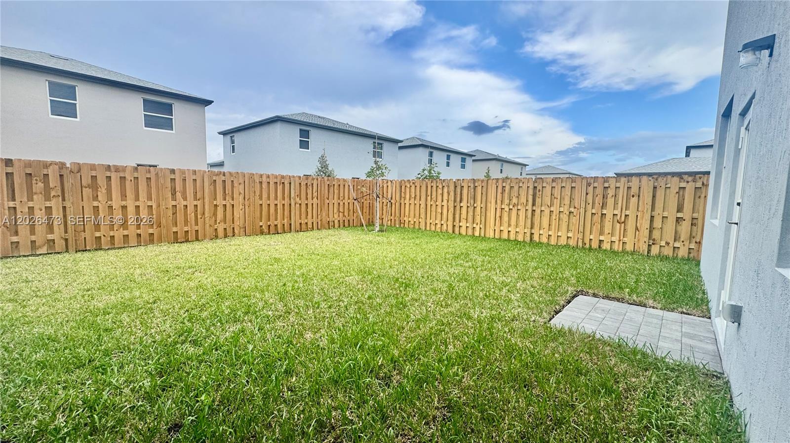 19479 Southwest 340th Street, Unit 1 Homestead, FL 33034 - Photo 47 of 58 a view of a backyard with brick wall and wooden fence