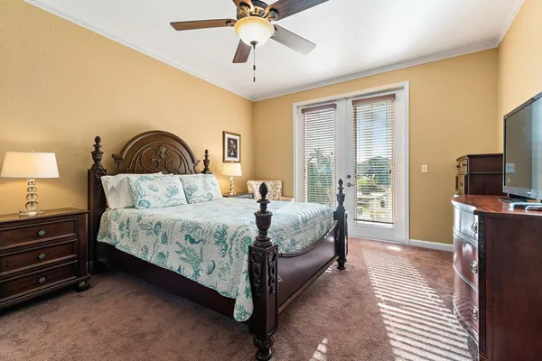 a bedroom with a bed and a flat screen tv on dresser