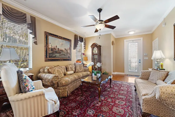 a living room with furniture a chandelier and a rug