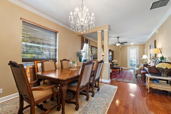 a kitchen with stainless steel appliances granite countertop a sink a stove cabinets dining table and chairs