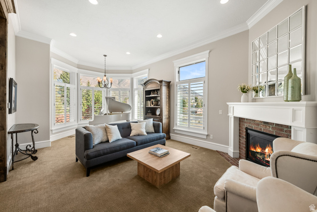 1205 North Elk Rdg Lane, Unit 202 Alpine, UT 84004 - Photo 11 of 88 Living area featuring a brick fireplace with a white mantel, bay windows with plantation shutters, crown molding, and recessed lighting