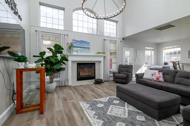 a living room with furniture a chandelier and a fireplace