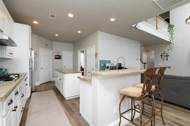 a kitchen with stainless steel appliances kitchen island granite countertop furniture and a refrigerator