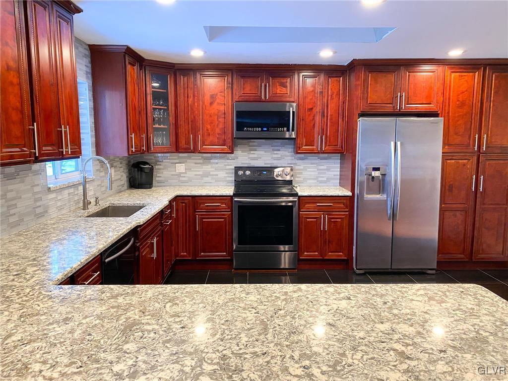 5901 Decker Road Bushkill, PA 18324 - Photo 5 of 49 a kitchen with stainless steel appliances wooden cabinets a sink and a stove