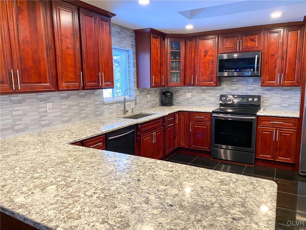 5901 Decker Road Bushkill, PA 18324 - Photo 6 of 49 a kitchen with stainless steel appliances granite countertop wooden cabinets a sink and dishwasher